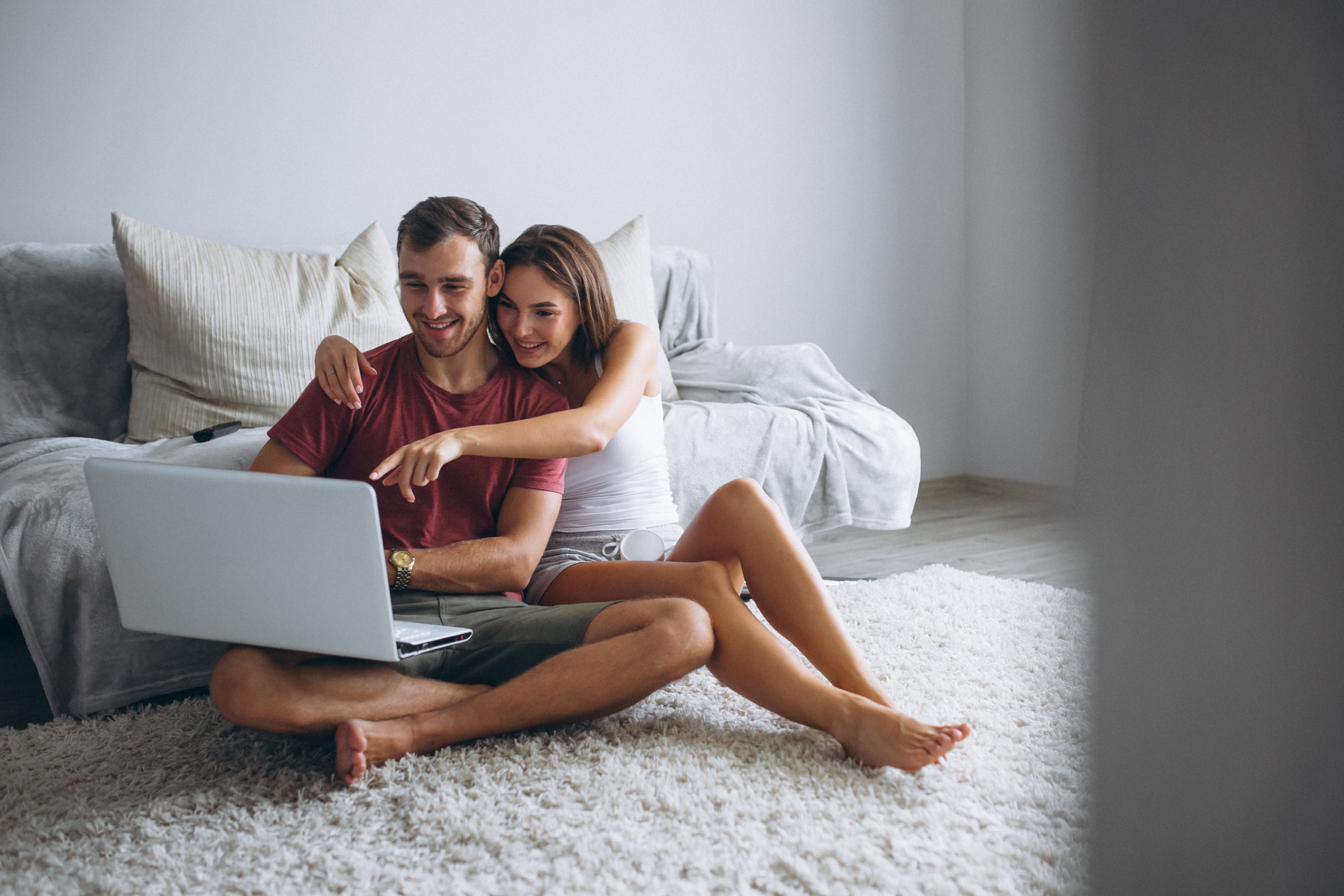 couple-at-home-together-sitting-on-floor-with-computer